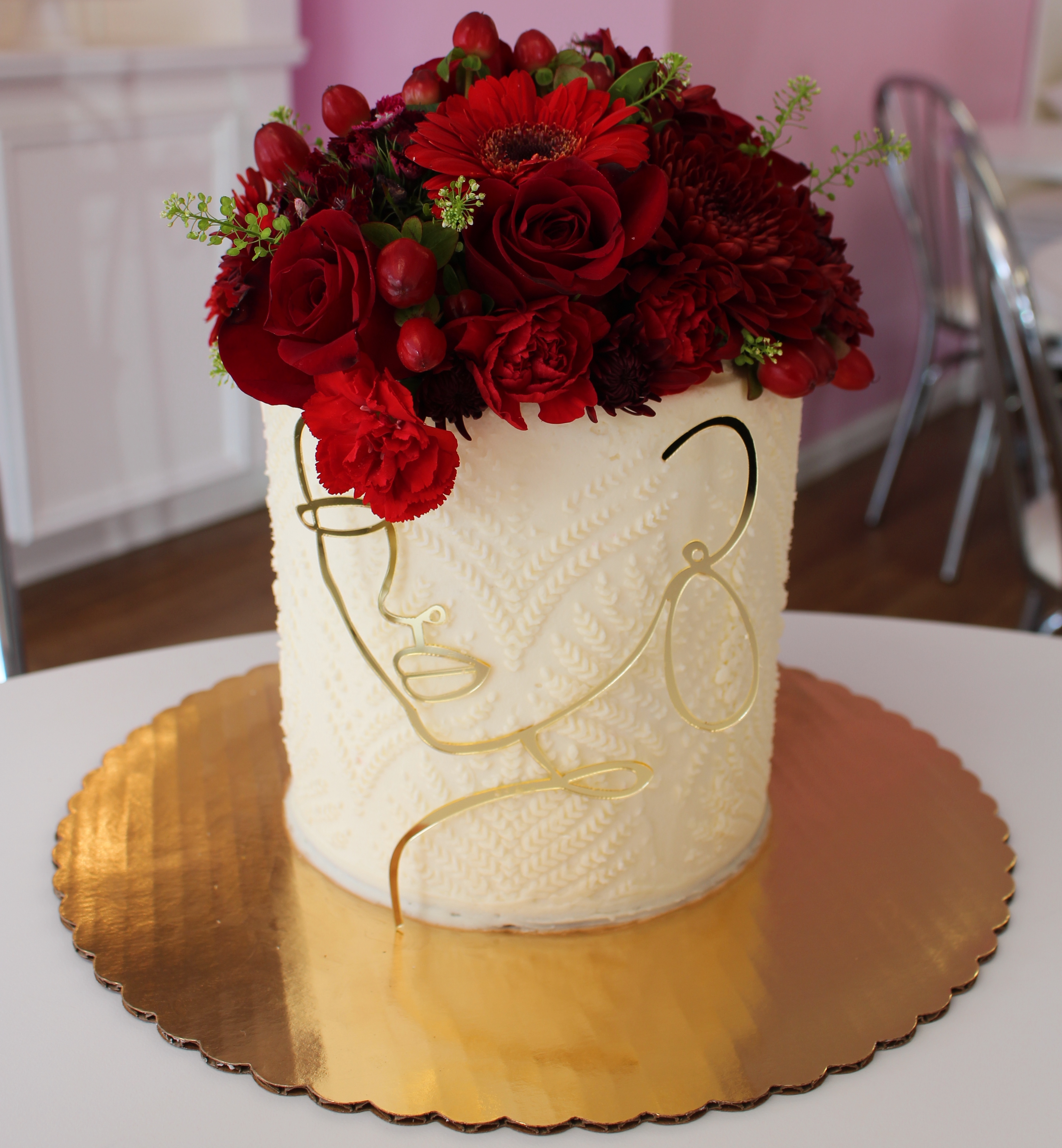 White Knitted Texture Cake with Gold Wiring Outline of Womans Face and Real Flowers