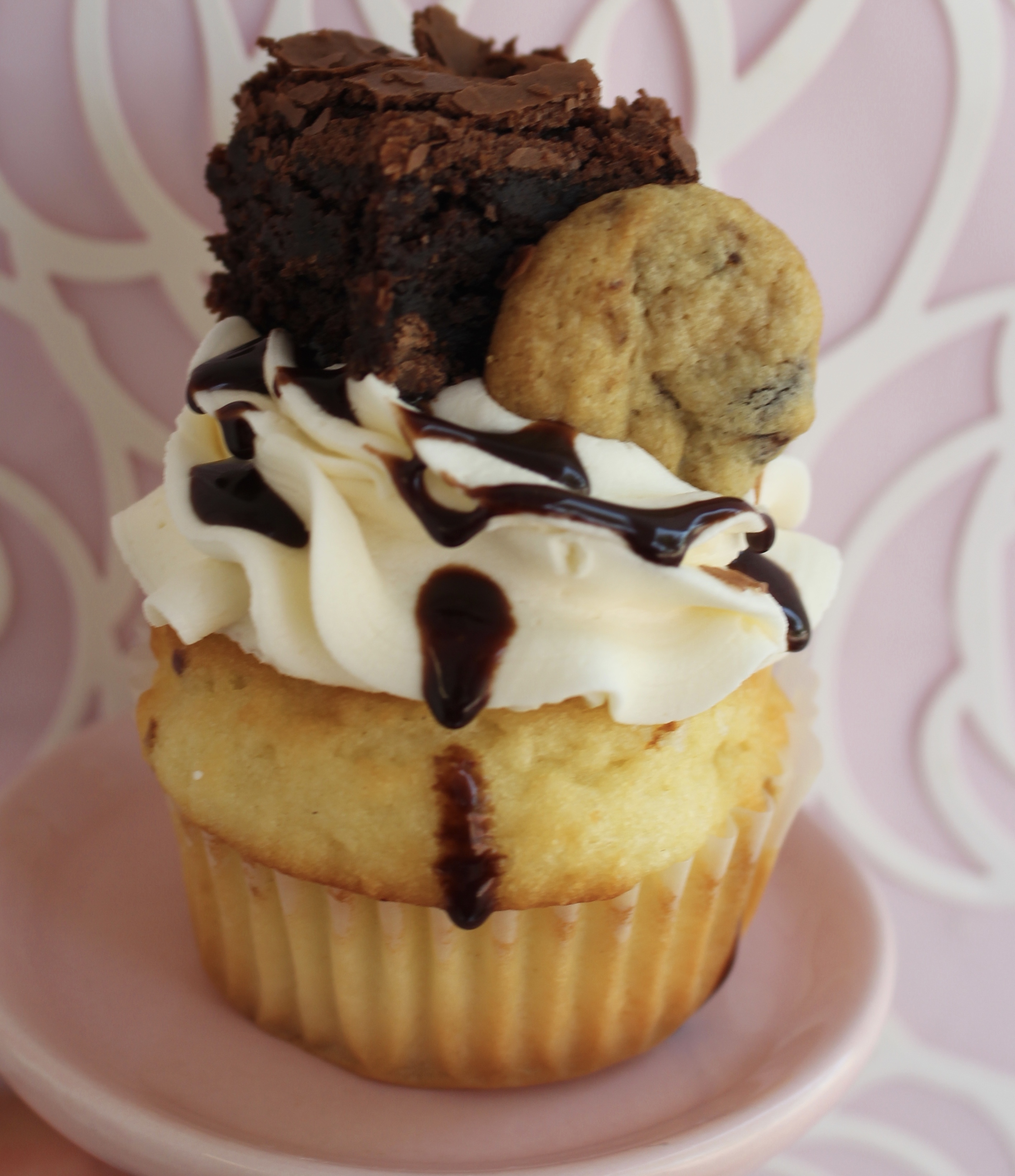 Vanilla or chocolate cake filled with a cookie dough buttercream and topped with vanilla buttercream, a mini brownie, and cookie!